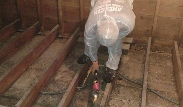 Technician installing floor insulation