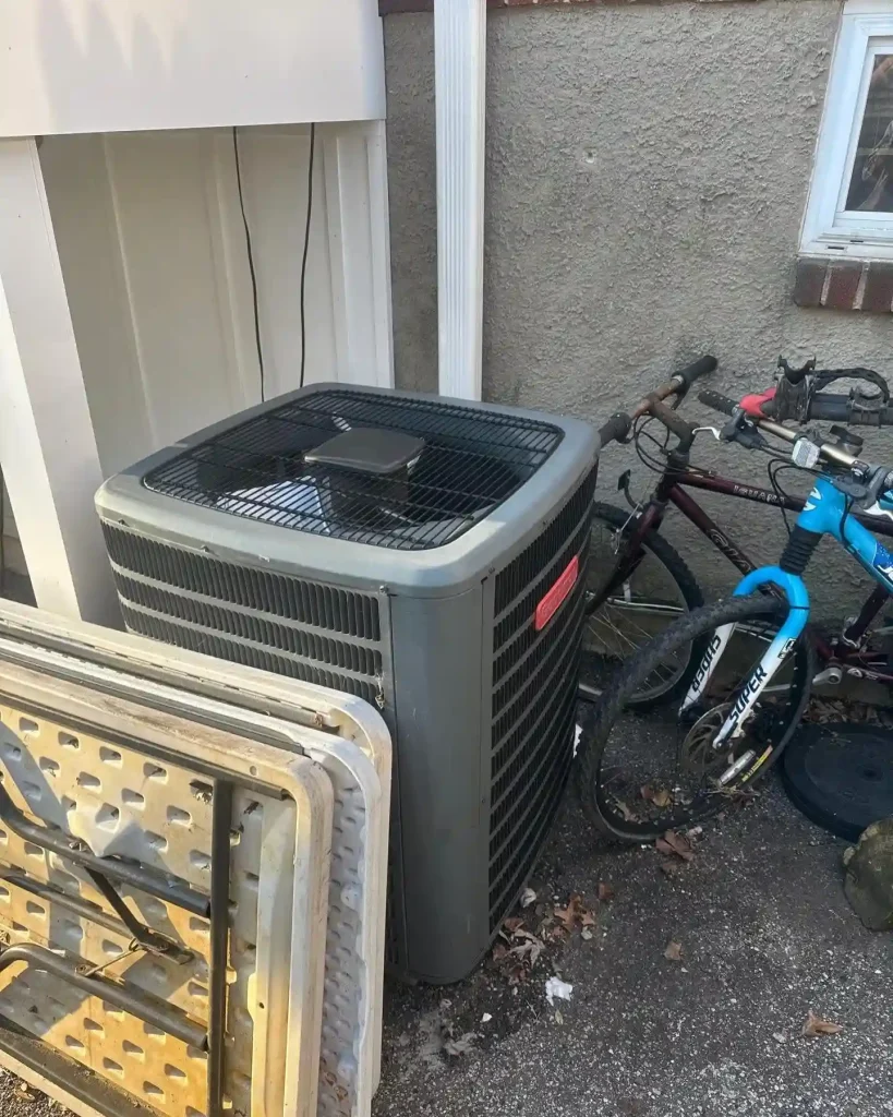 Technician performing HVAC maintenance on an outdoor unit in June